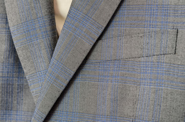Close up of light grey and blue checked woolen jacket.