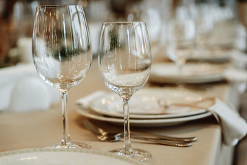 Festive table setting. Glasses, plates, cutlery, napkins. Defocus