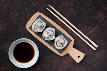 table with sushi and chopsticks with bowl of soy sauce