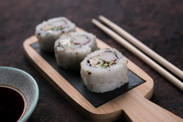 table with sushi and chopsticks with bowl of soy sauce