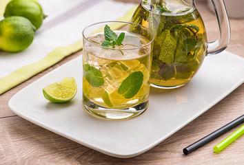 Apple Mojito with Lime, Mint and Cocktail Tube on White Stand with Transparent Decanter.
