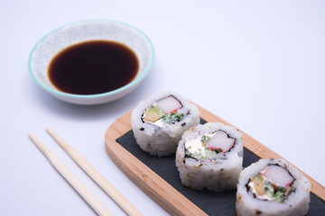 table with sushi and chopsticks with bowl of soy sauce