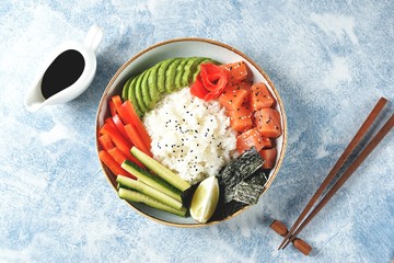 Sushi bowl with rice, salmon, avocado, cucumber, sweet pepper, ginger and sesame. Healthy food.