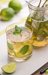 Apple Mojito with Lime, Mint and Cocktail Tube on White Stand with Transparent Decanter.