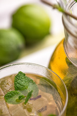 Apple Mojito with Lime, Mint and Cocktail Tube on White Stand with Transparent Decanter.