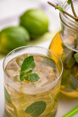 Apple Mojito with Lime, Mint and Cocktail Tube on White Stand with Transparent Decanter.