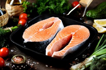 Two raw salmon steaks in a grill pan.