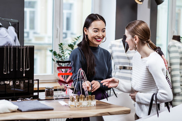 Brunette beautiful asian woman in a navy polo neck and her friend looking involved