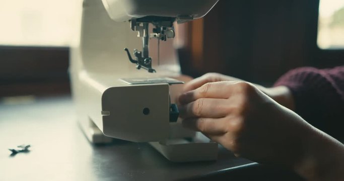 Young woman threading her sewing machine