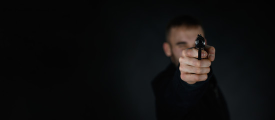 Man with a pistol in the hand aims his target