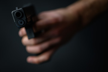 Man with a pistol in the hand closeup