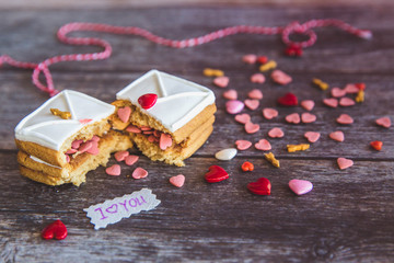 Baking Surprise Cookies with topping and icing on wooden background with pink heart