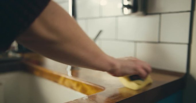 Woman cleaning worktop in kitchen