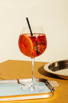 Spritz veneziano, an international italian cocktail with Prosecco or white sparkling wine, bitter, soda, ice and a slice of orange, in a calix on a table, pop graphic style
