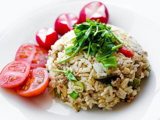 Delicious Thai traditional food, spicy fried Jasmine rice with chilli shrimp paste dip and vegetables on white plate.