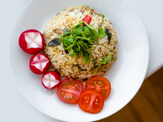 Delicious Thai traditional food, spicy fried Jasmine rice with chilli shrimp paste dip and vegetables on white plate.