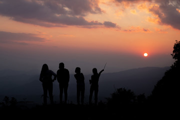 Group of happy people playing at summer sunset in nature