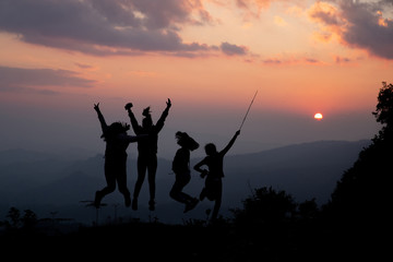 Group of happy people playing at summer sunset in nature