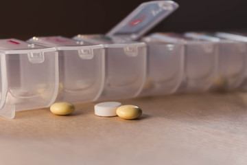  The pill organiser with pills are on the paper background