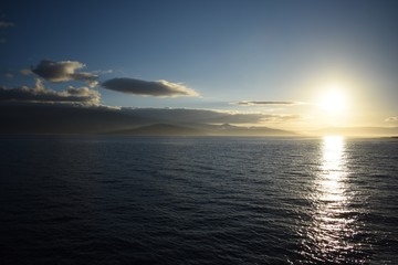 Sunset view behind the mountain while on the ocean