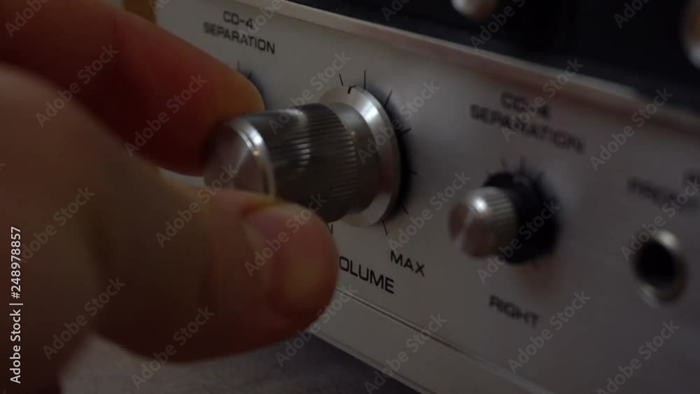 Poster pushing buttons and twisting knobs on an old amplifier.