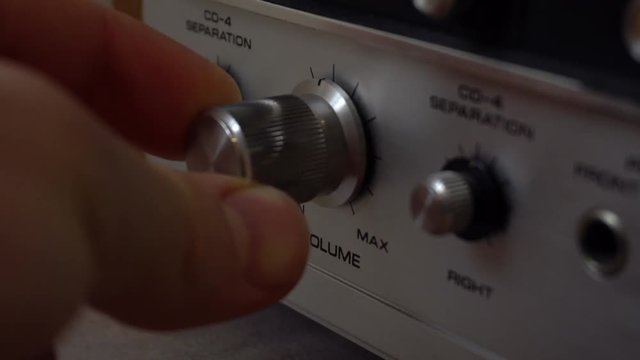 Pushing buttons and twisting knobs on an old amplifier.