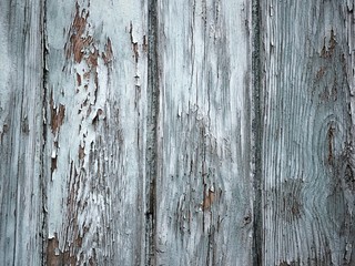 Old wooden pattern combined by boards and planks, rusty elements painted with blue paint. Textures, damaged pieces of an old gate