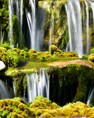 waterfall splashing on mossy rocks below