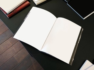White opened diary, book, notebook on a black table desk. Mockup, mock-up