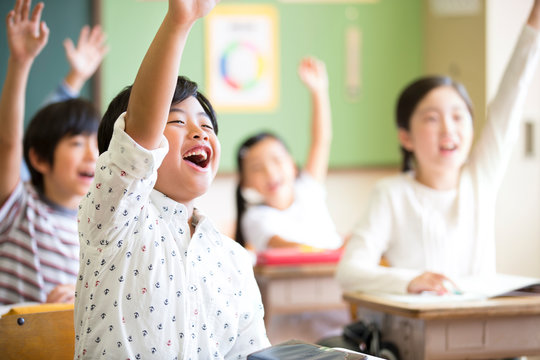 授業中に手を上げる小学生たち