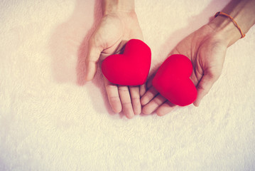 Fototapeta premium Top view hand holding red heart for valentine day concept, romantic love forever.