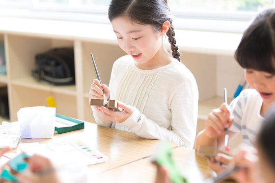 絵具の筆で色を塗る女の子