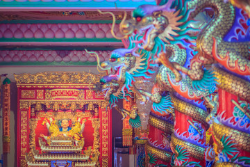Fototapeta na wymiar Colorful dragons and statue of Nezha, the protective deity in Chinese folk religion at Chinese public temple.