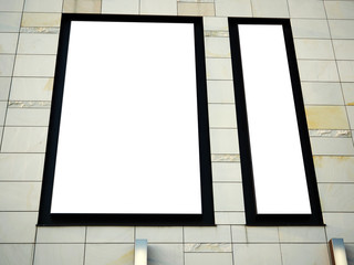 Big signboard billboard view of empty white mock up, mock-up signage in a black frame on a shopping centre, gallery wall, display panel exterior 