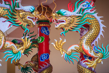 Colorful statue of Chinese dragon wrapped around red pillar. Beautiful statue of dragon carved around temple pole in Chinese public temple.