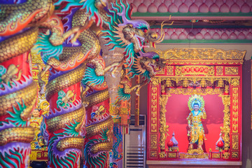 Colorful dragons and statue of Nezha, the protective deity in Chinese folk religion at Chinese public temple.