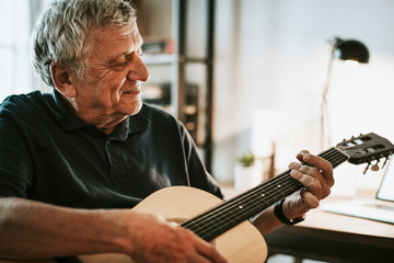 Senior man playing on his guitar