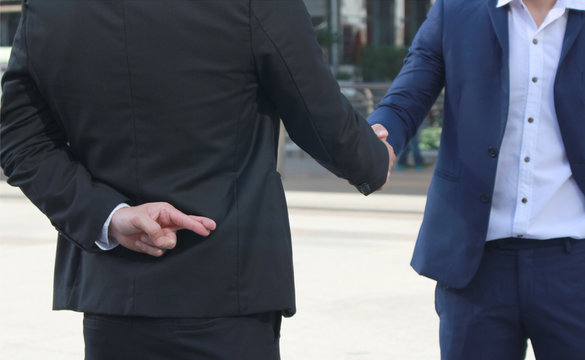 Business man shaking hand with lie sign