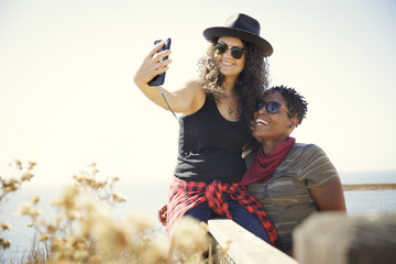 Two women smiling while taking a selfie on a hike