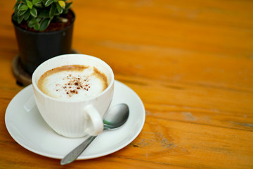 Cup of coffee on the wooden table.