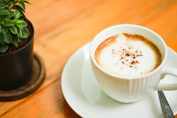 Cup of coffee on the wooden table.