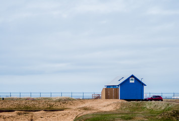 Fototapeta na wymiar blue house, field and sky clouds
