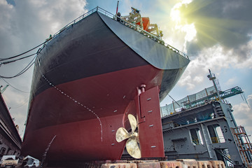 aft stern of the commercial ship in floating dry dock, painting , repairing, recondition of overhaul, ship sitting on supporter bottom of dry dock terminal © ID_Anuphon