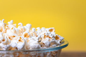 popcorn in bowl on yellow background 