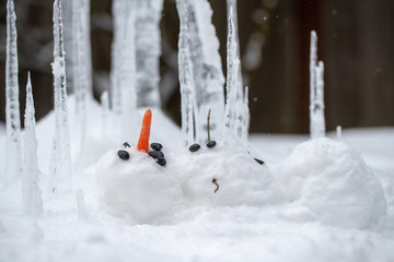 Bloody dead snowman impaled on a sharp icicle during a winter storm