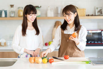 attractive asian women cooking in kitchen