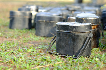 Obraz premium pot for camping,Black pot and golden food plate for soldiers in field training.black Strand