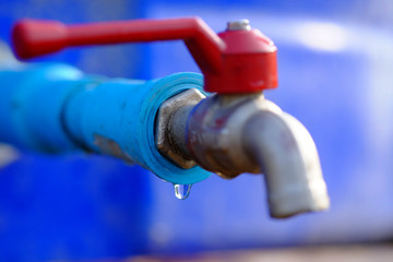 Drops of water under the blue water pipes and red faucets.