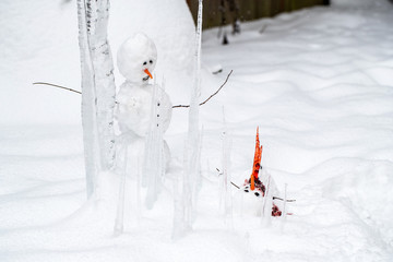 Bloody dead snowman impaled on a sharp icicle during a winter storm