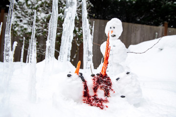 Bloody dead snowman impaled on a sharp icicle during a winter storm